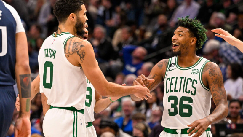 Boston Celtics players celebrating on the court during a basketball game.