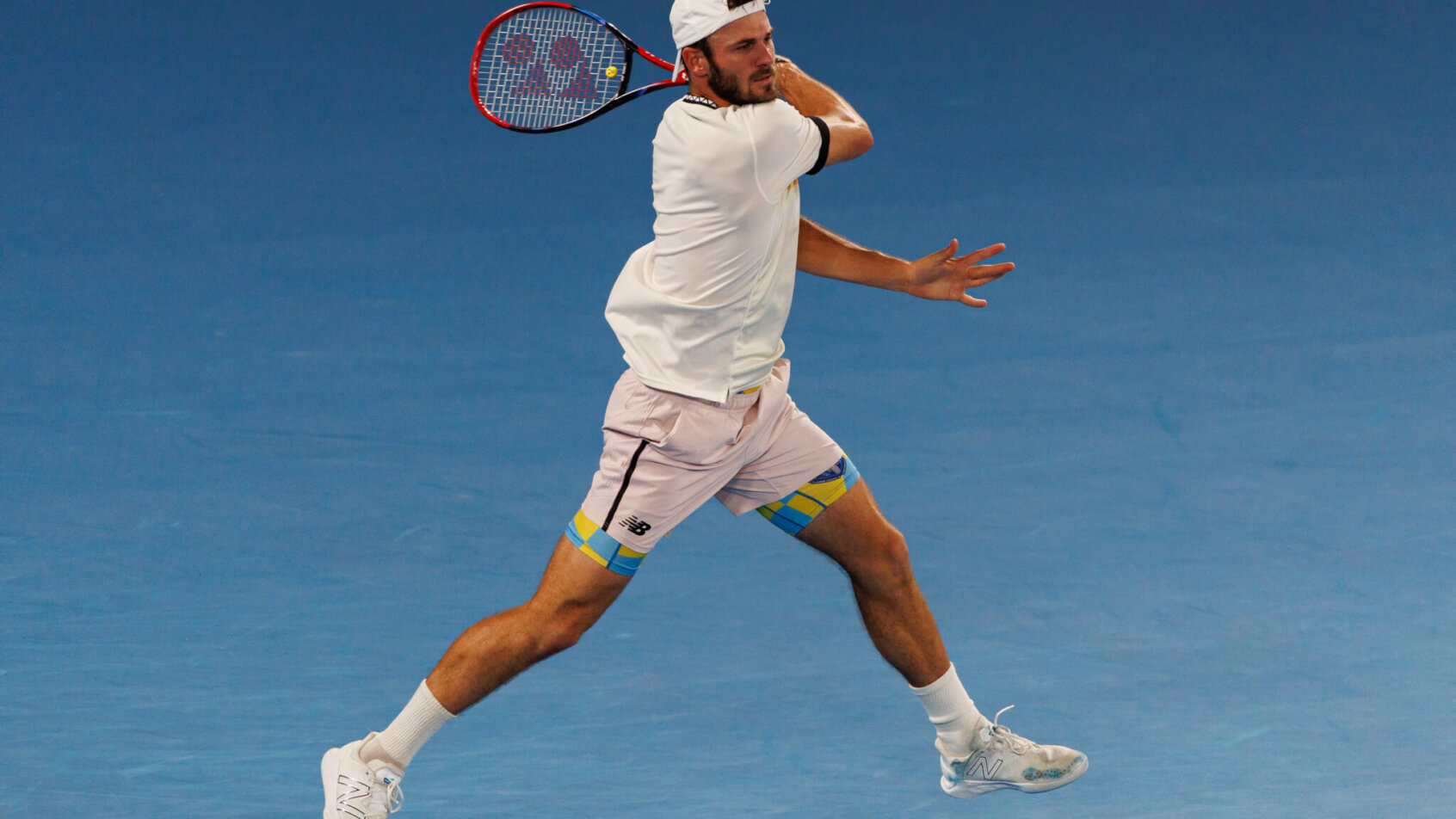 Tommy Paul following through on a forehand hit during a tennis match.