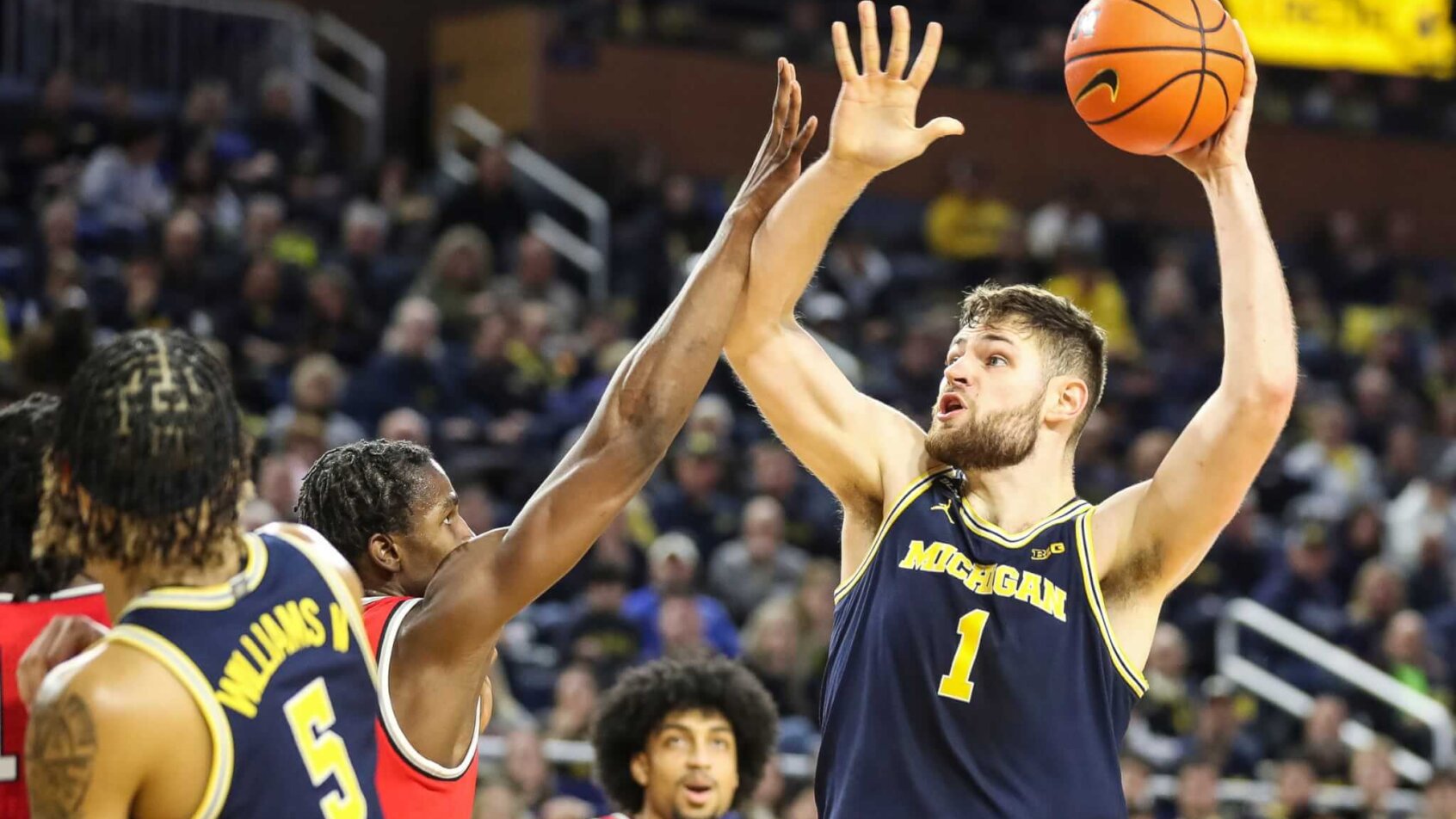 Michigan center Hunter Dickinson shooting over a defender