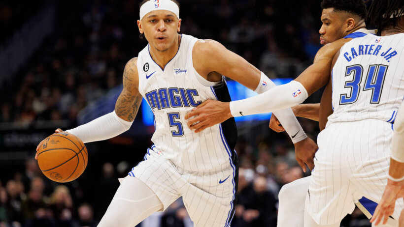 Orlando Magic forward Paolo Banchero dribbling around a defender