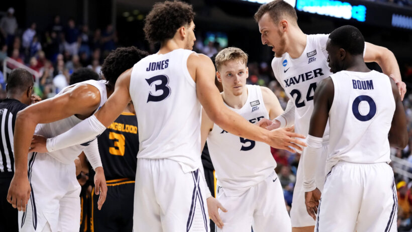 Xavier Musketeers players huddling on the court