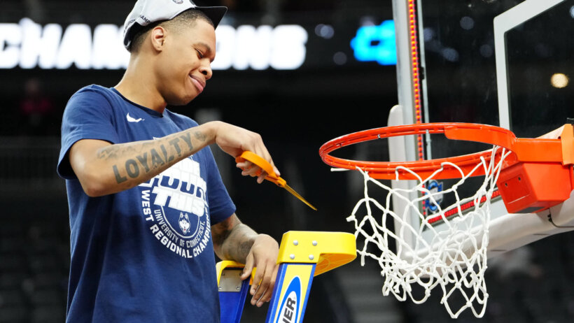 Connecticut Huskies guard Jordan Hawkins cuts down the nets