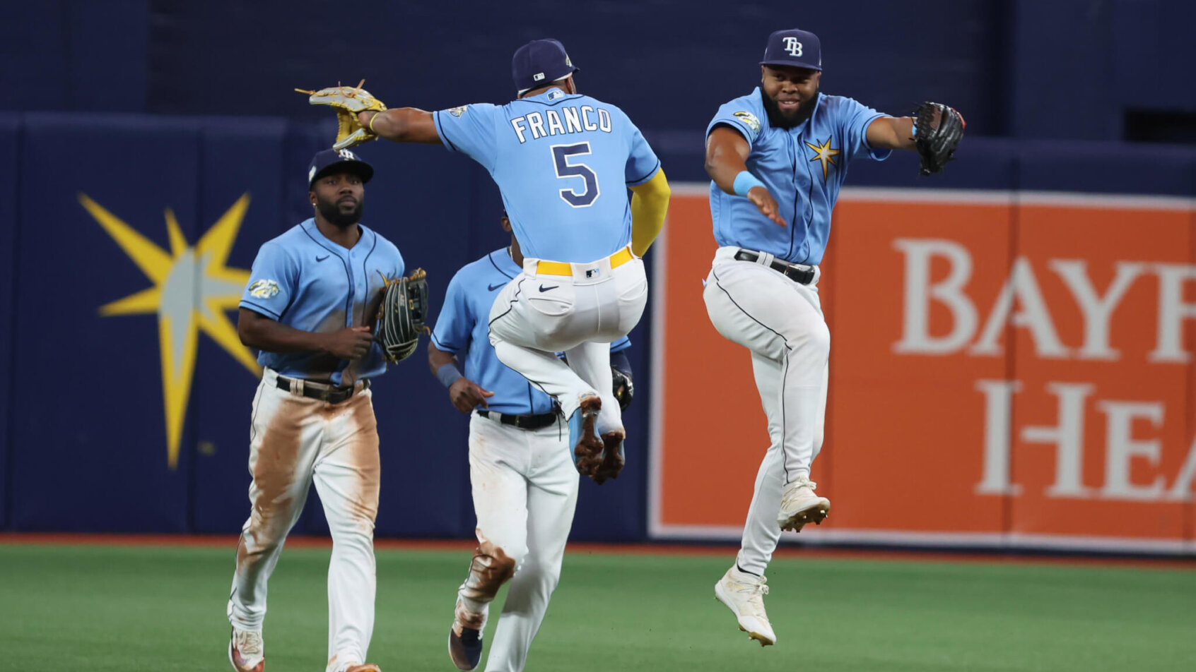 Tampa Bay Rays players celebrating in the outfield.