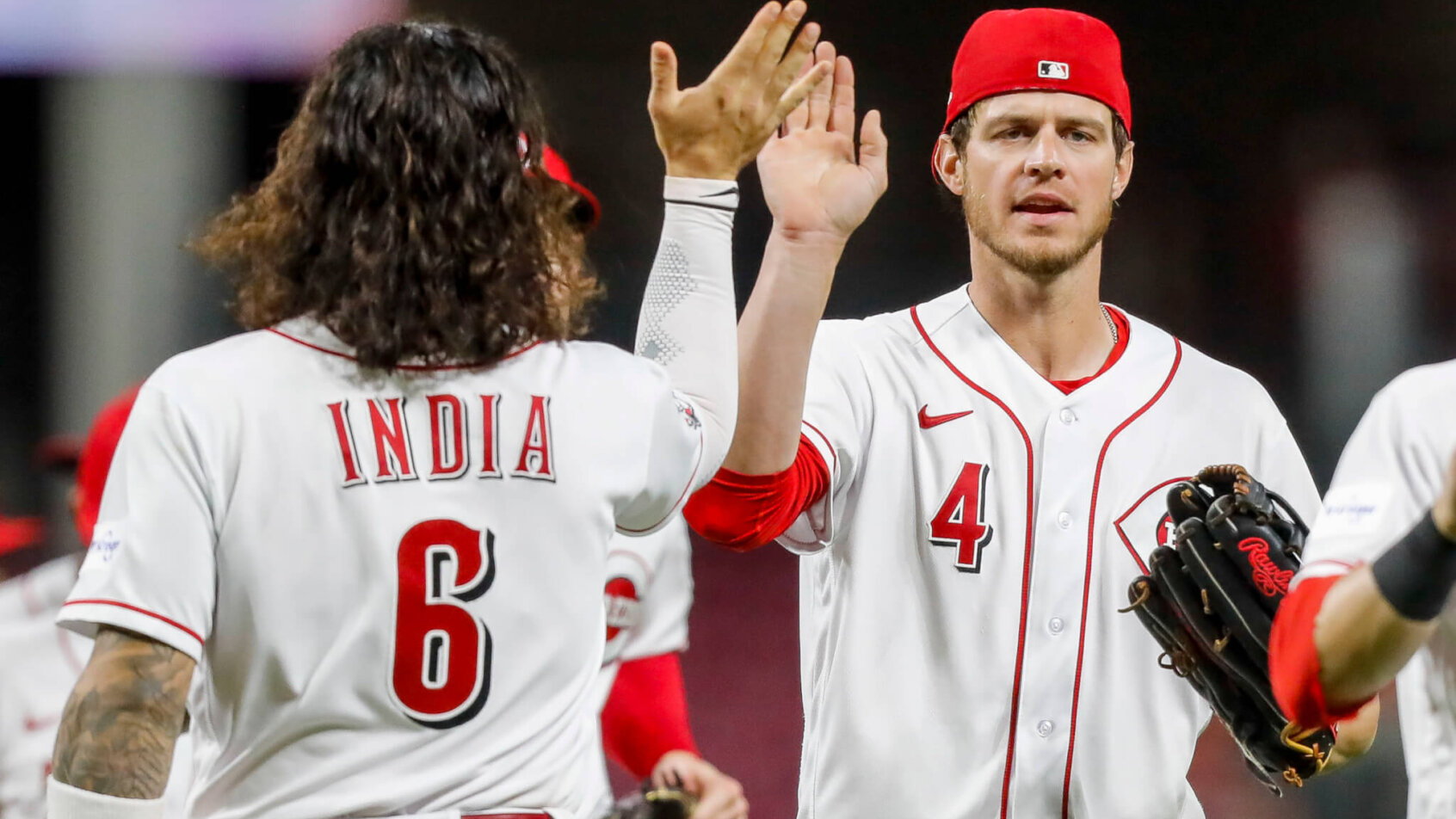 Cincinnati Reds right fielder Wil Myers high fives teammate Jonathan India