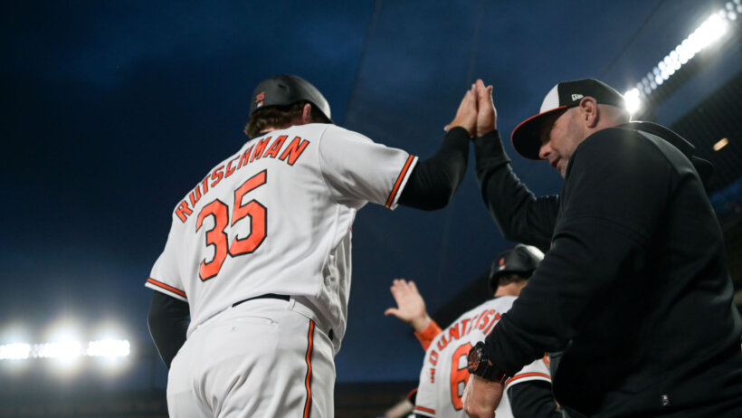 Baltimore Orioles catcher Adley Rutschman celebrates scoring a run with teammates