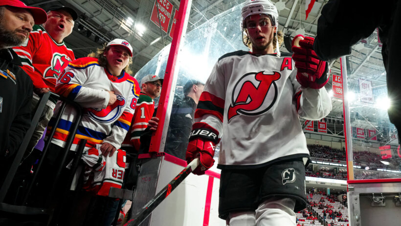 Jack Hughes high-fives a fan