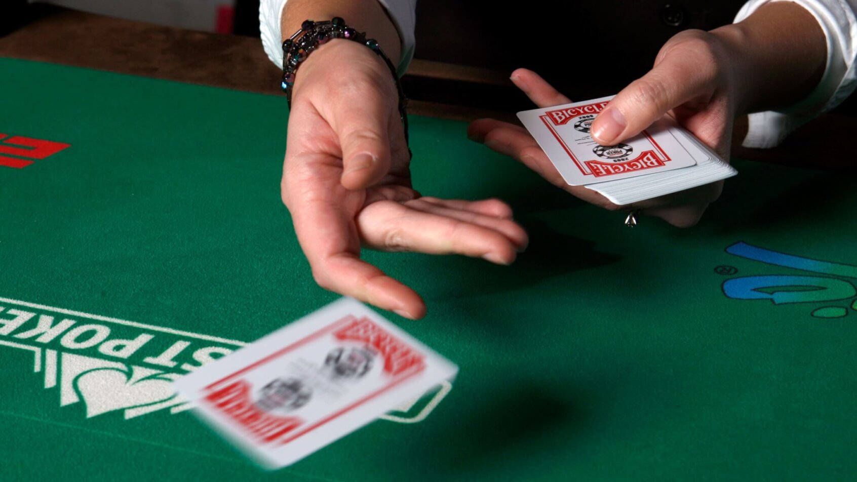 Casino dealer dealing out cards green casino table