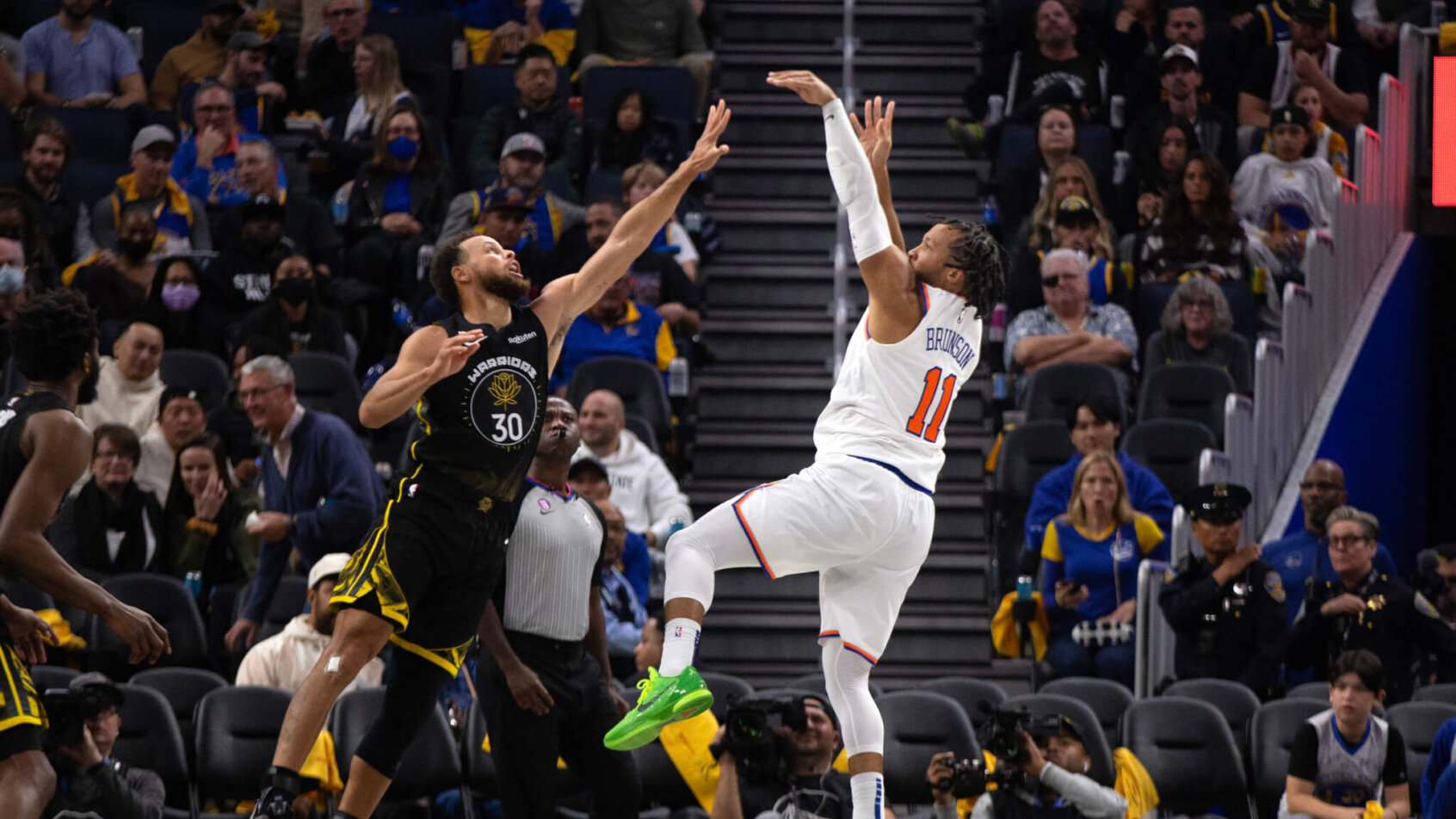 New York Knicks guard Jalen Brunson shoots over Golden State Warriors guard Stephen Curry