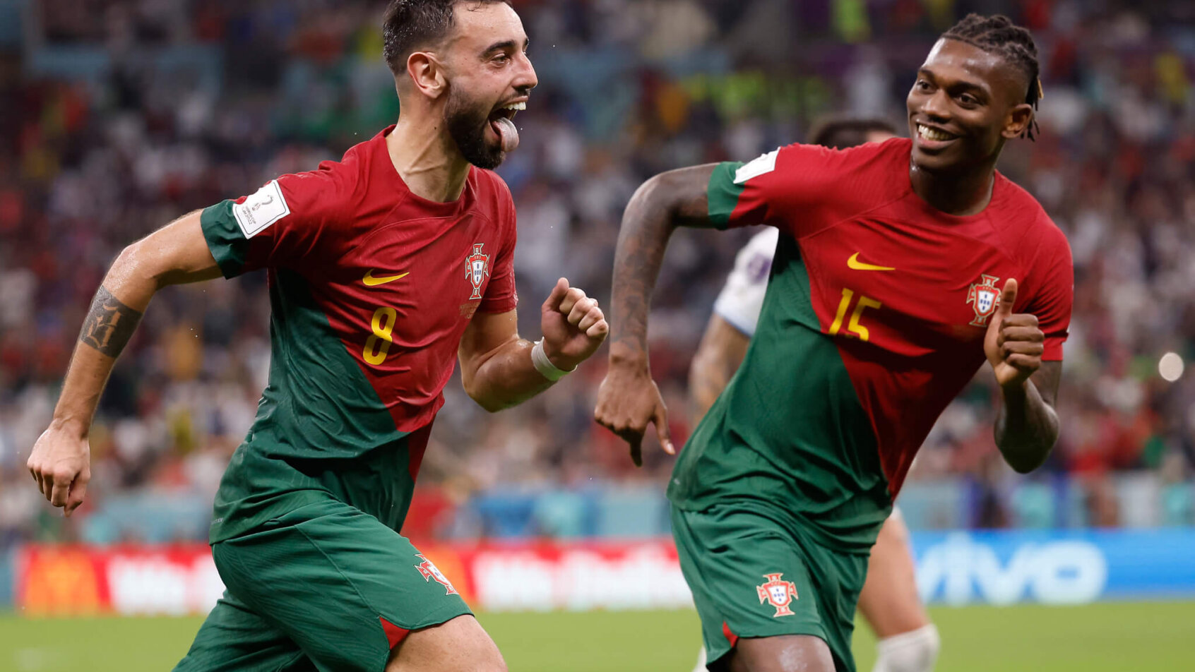 Portuguese soccer players Bruno Fernandes and Rafael Leao running & celebrating.