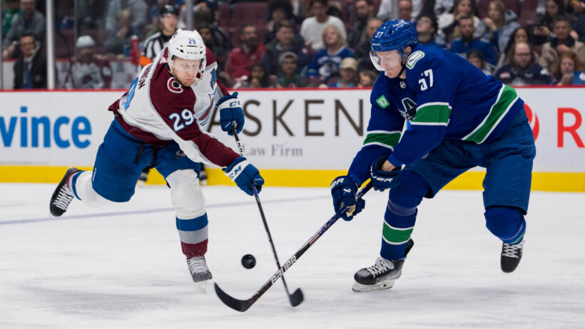 Nathan MacKinnon and Tyler Myers battle for the puck