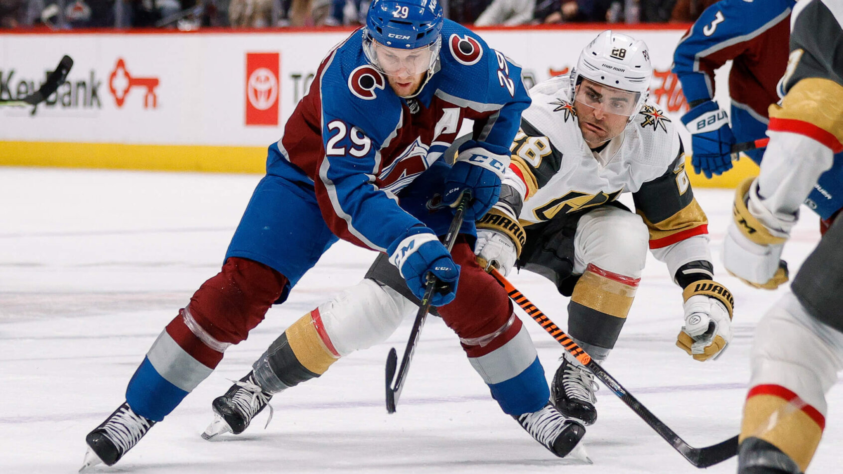 Colorado Avalanche center Nathan MacKinnon controls the puck under pressure from Vegas Golden Knights