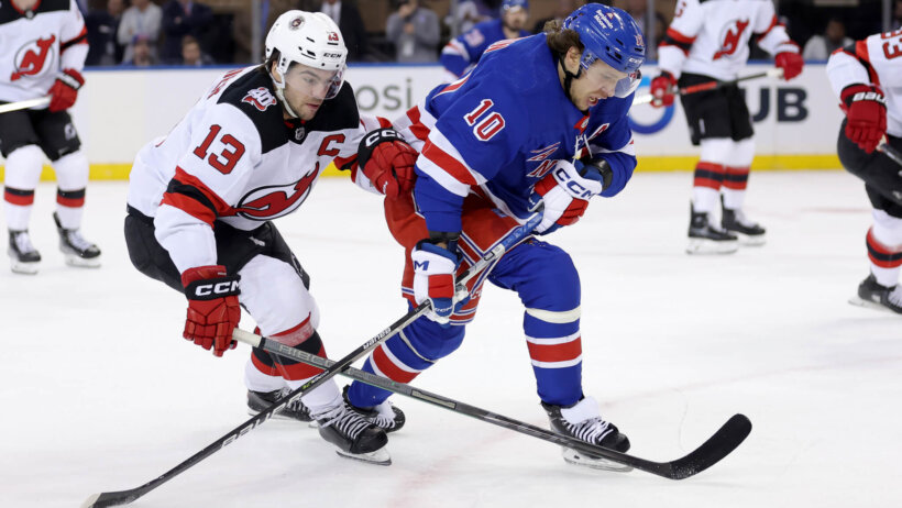 New York Rangers left wing Artemi Panarin fights for the puck against New Jersey Devils center Nico Hischier