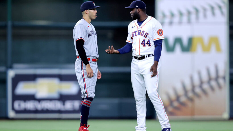Minnesota Twins shortstop Carlos Correa talks with Houston Astros designated hitter Yordan Alvarez