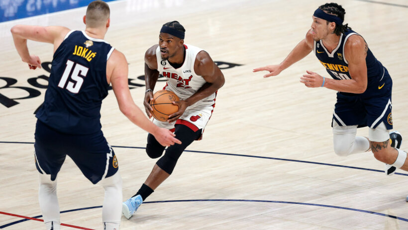 Jimmy Butler driving against Nuggets defenders during the 2023 NBA Finals.