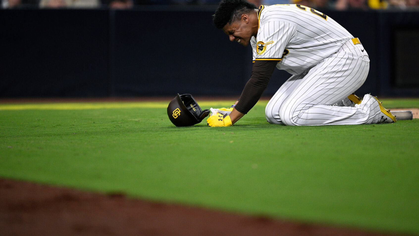 San Diego Padres left fielder Juan Soto kneels on the grass