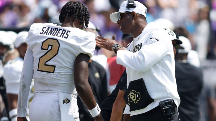Colorado Buffaloes head coach Deion Sanders talks to quarterback Shedeur Sanders (2) after a touchdown in the fourth quarter against the TCU Horned Frogs.
