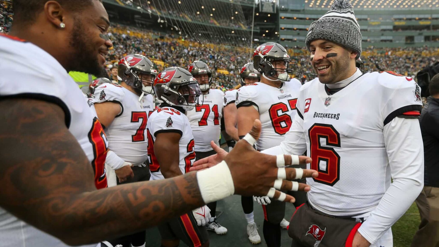 Tampa Bay Buccaneers quarterback Baker Mayfield (6) slaps hands with guard Nick Leverett