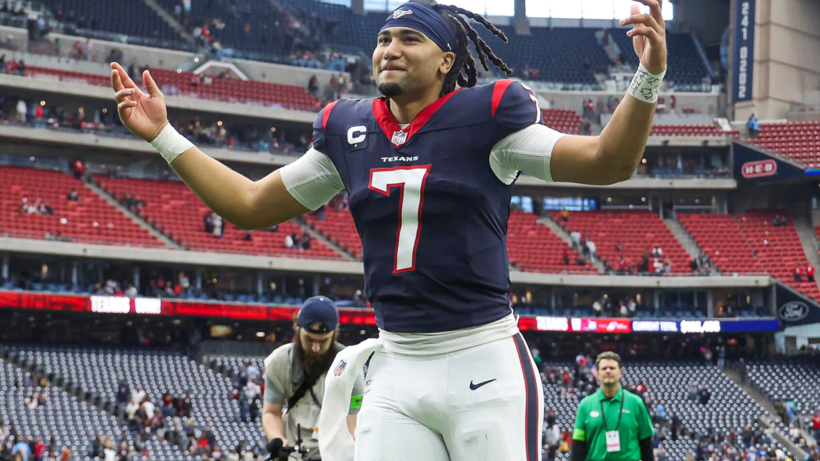 Houston Texans QB C.J. Stroud running hands up blue jersey