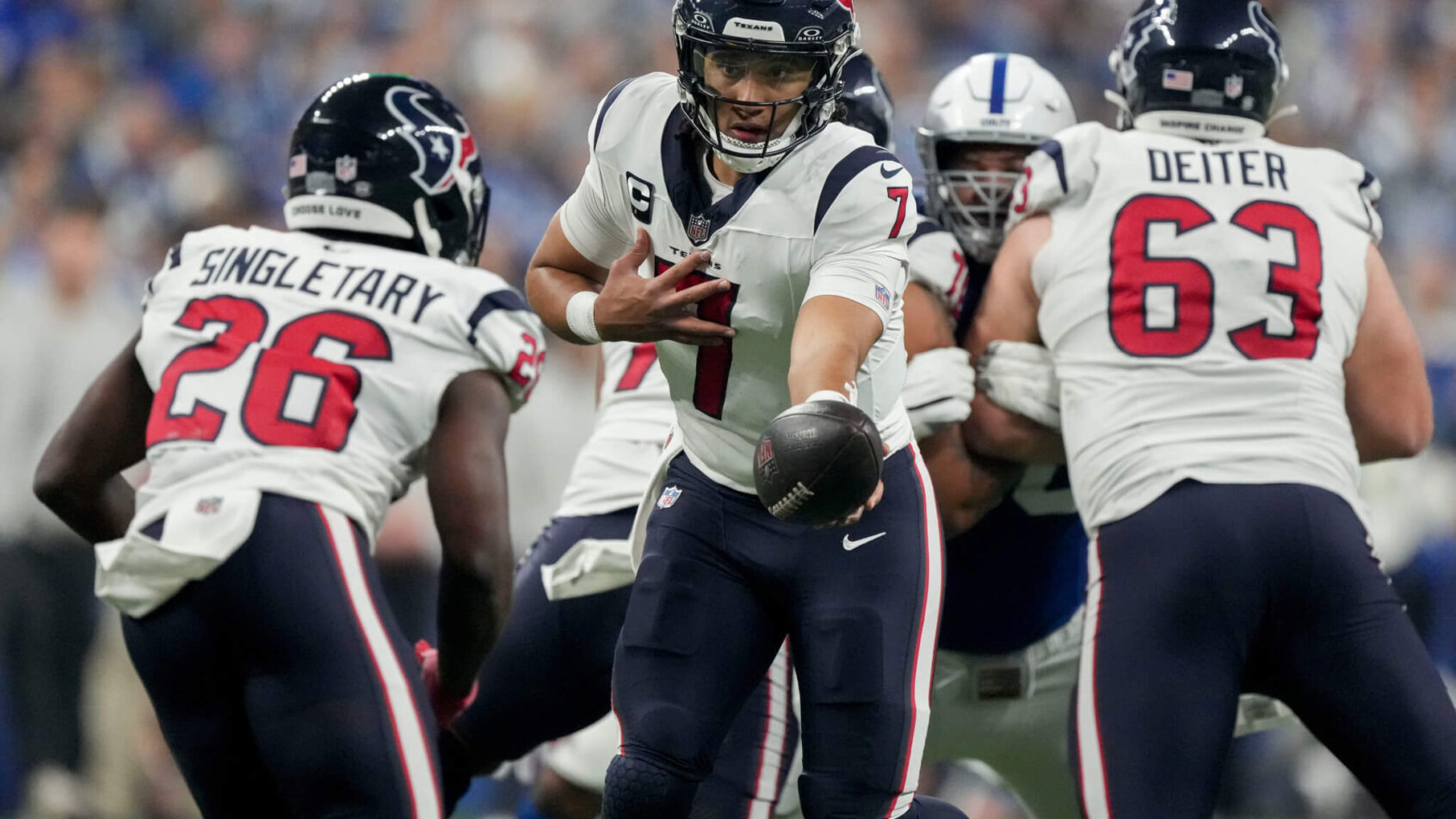 Houston Texans quarterback C.J. Stroud (7) looks to hand the ball off to Houston Texans running back Devin Singletary