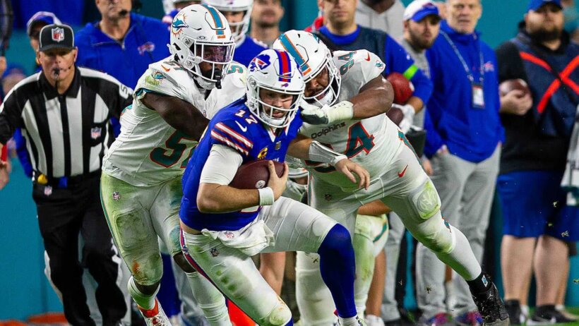 Buffalo Bills quarterback Josh Allen (17), runs by several Dolphins defenders