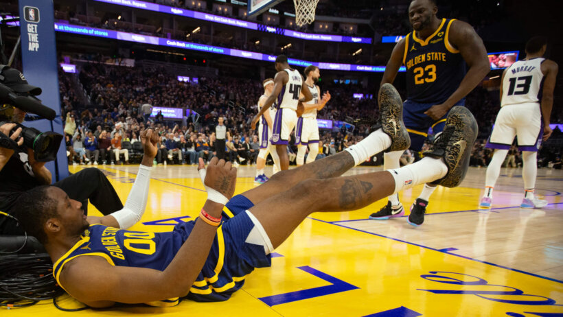 Golden State Warriors forward Jonathan Kuminga laying on the court after making a basket