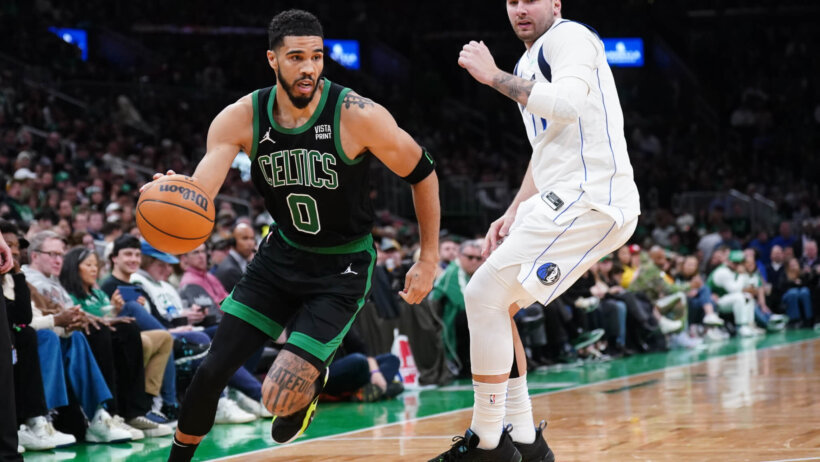 Boston Celtics forward Jayson Tatum dribbles around Dallas Mavericks guard Luka Doncic