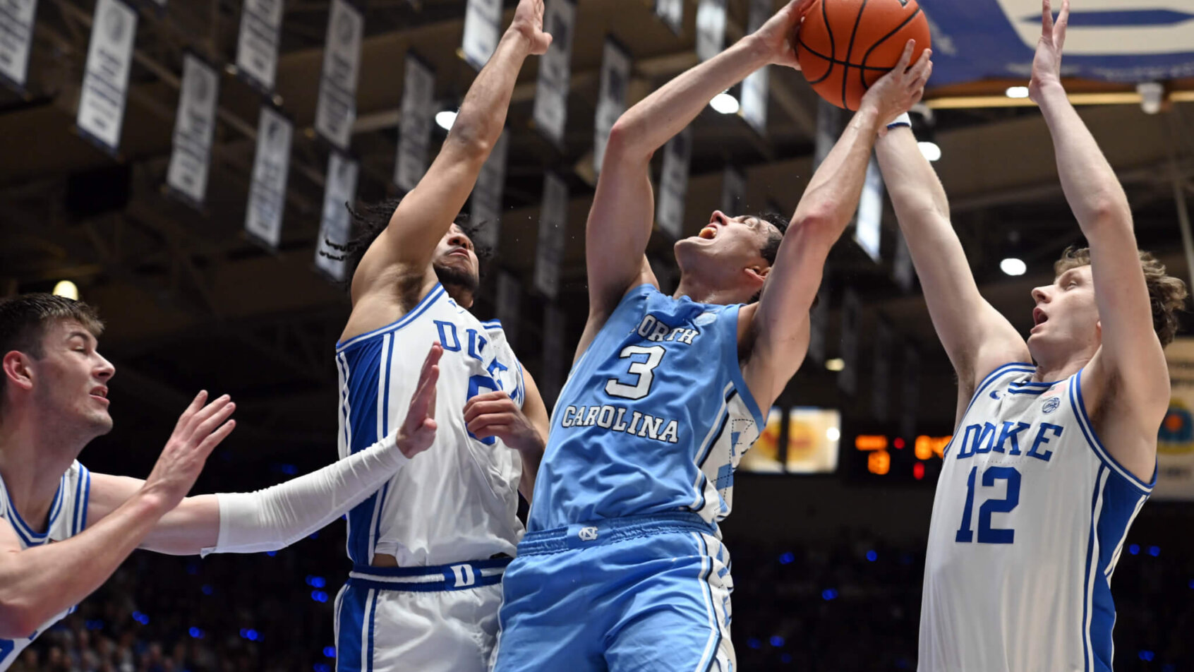 North Carolina player shooting over Duke defenders