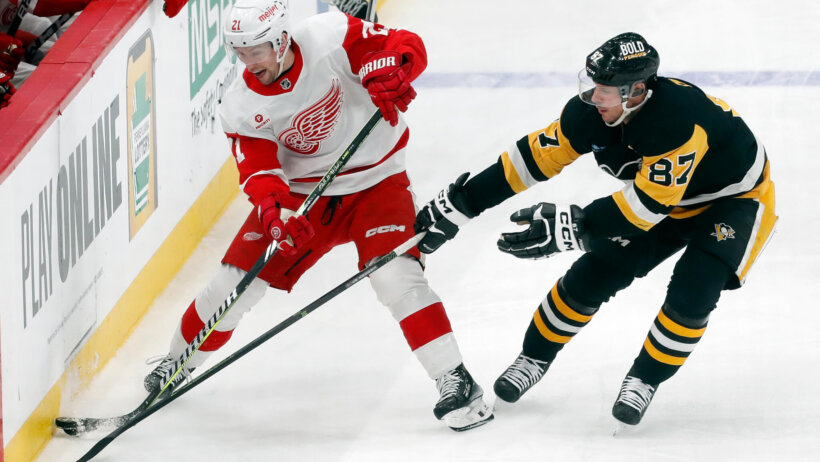 Detroit Red Wings center Austin Czarnik moves the puck against Pittsburgh Penguins center Sidney Crosby