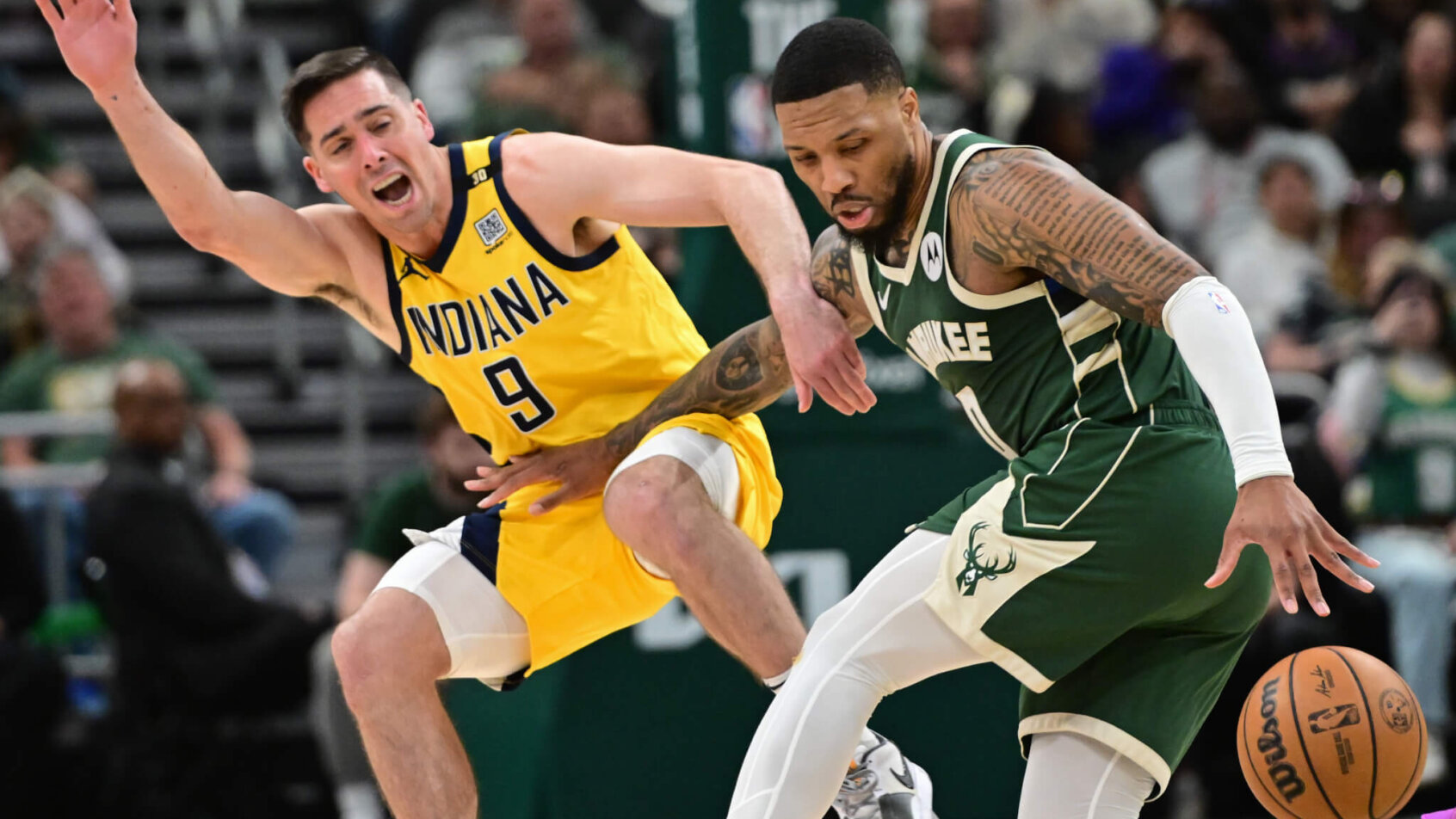 Milwaukee Bucks guard Damian Lillard dribbles around Indiana Pacers guard TJ McConnell