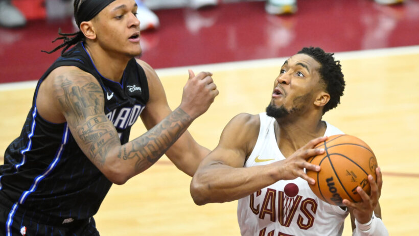 Cleveland Cavaliers guard Donovan Mitchell (45) drives against Orlando Magic forward Paolo Banchero in the fourth quarter