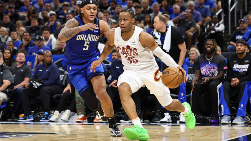 Cleveland Cavaliers forward Isaac Okoro tries to dribble around Orlando Magic forward Paolo Banchero