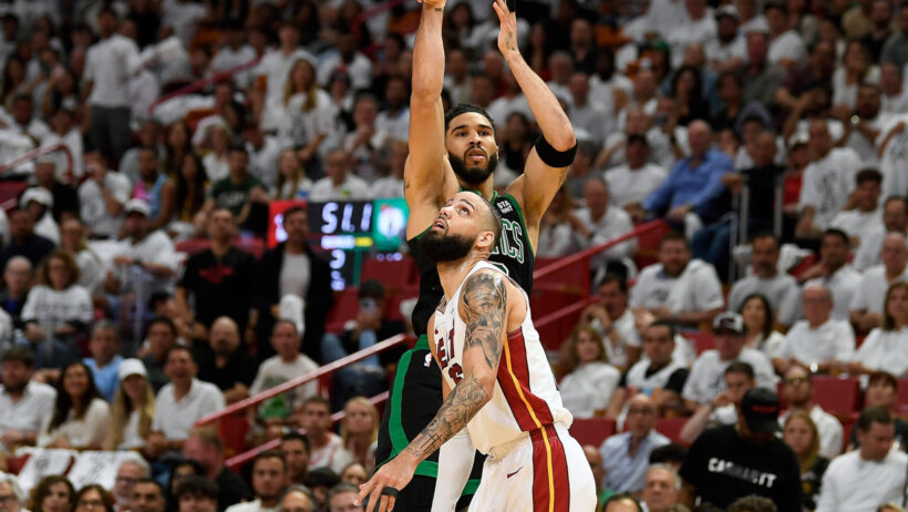 Boston Celtics forward Jayson Tatum shoots a three over Miami Heat forward Caleb Martin