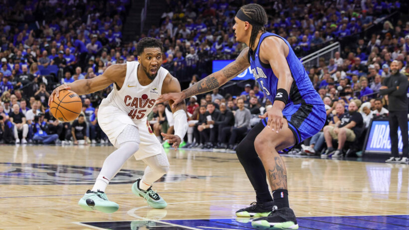 Cleveland Cavaliers guard Donovan Mitchell dribbles while Orlando Magic forward Paolo Banchero defends