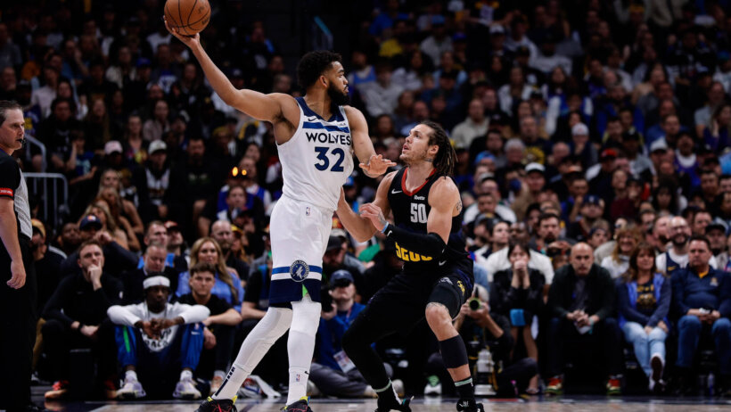 Minnesota Timberwolves forward Karl-Anthony Towns holds off Denver Nuggets forward Aaron Gordon