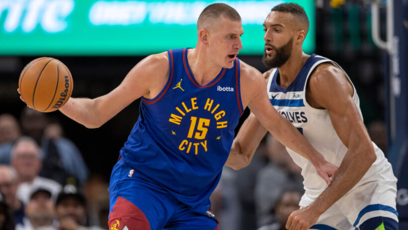 Denver Nuggets center Nikola Jokic holds the ball as Minnesota Timberwolves center Rudy Gobert defends