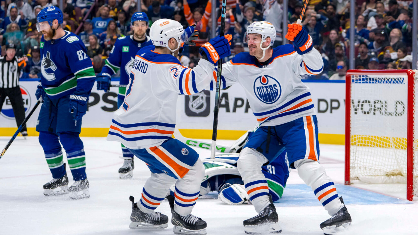 Edmonton Oilers defenseman Evan Bouchard and forward Zach Hyman celebrate Bouchard’s game winning goal against the Vancouver Canucks