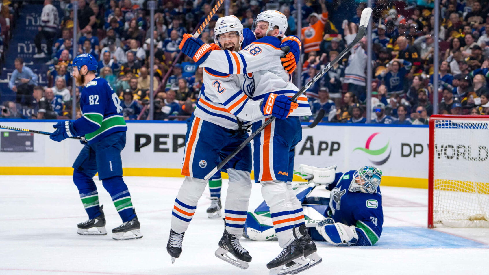 Edmonton Oilers defenseman Evan Bouchard and forward Zach Hyman celebrate an OT goal against the Vancouver Canucks