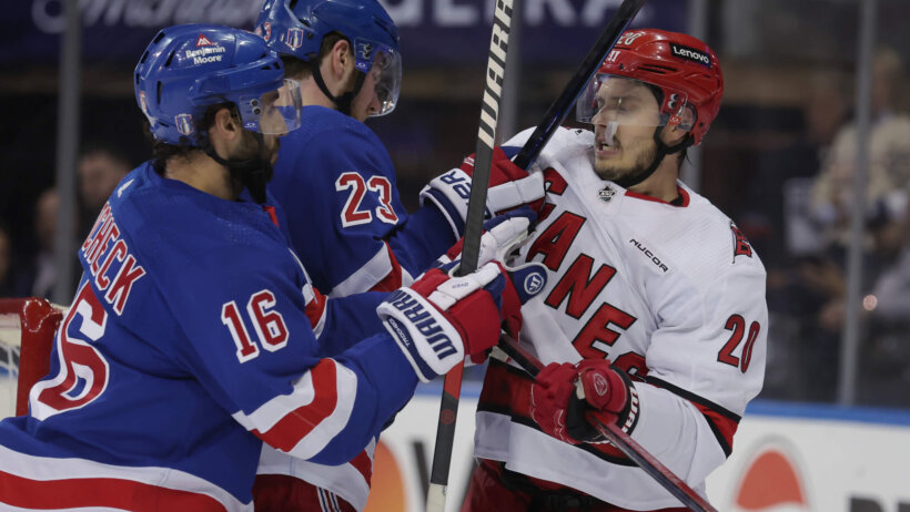Carolina Hurricanes center Sebastian Aho (20) skates against New York Rangers defenseman Adam Fox and center Vincent Trocheck