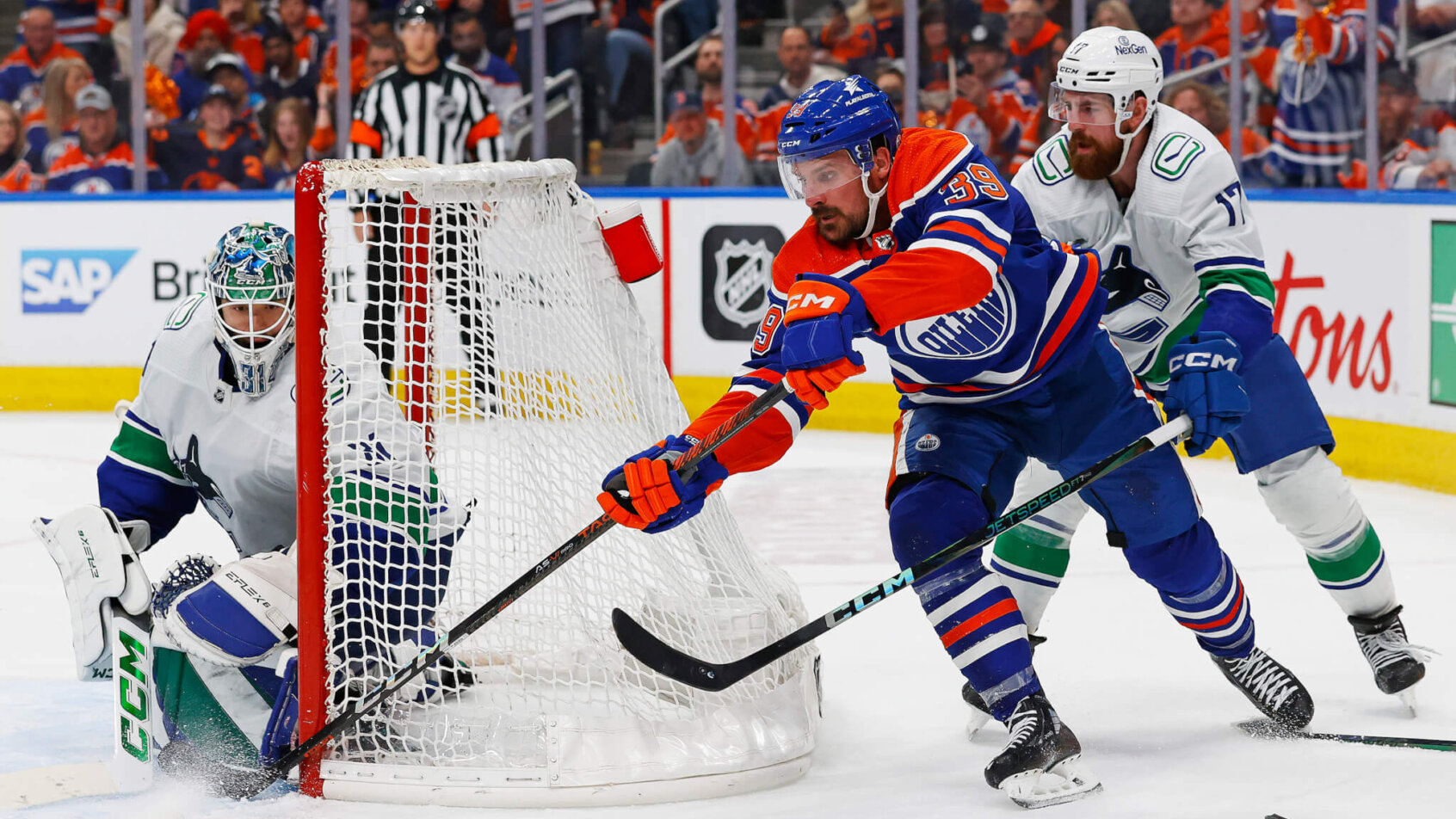 Edmonton Oilers forward Sam Carrick goes for a wraparound against Vancouver Canucks goaltender Arturs Silovs