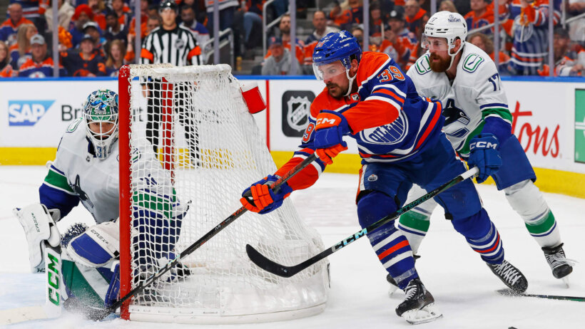 Edmonton Oilers forward Sam Carrick goes for a wraparound against Vancouver Canucks goaltender Arturs Silovs