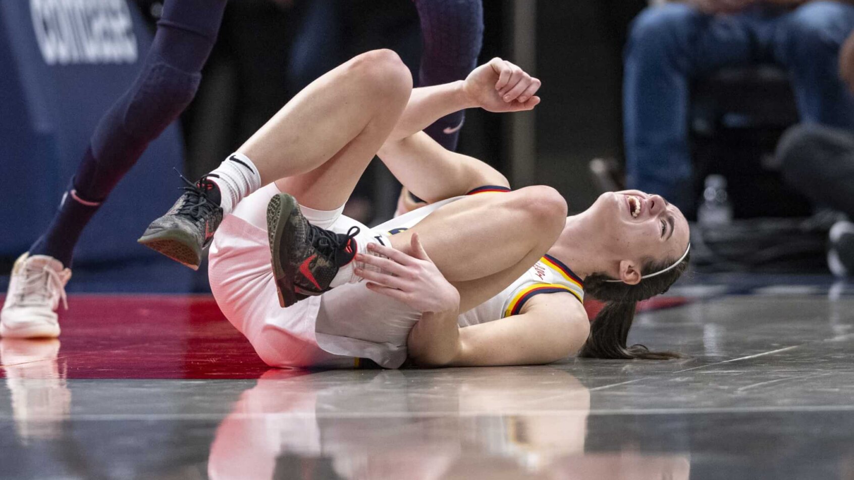 Indiana Fever guard Caitlin Clark on the ground after suffering an ankle injury