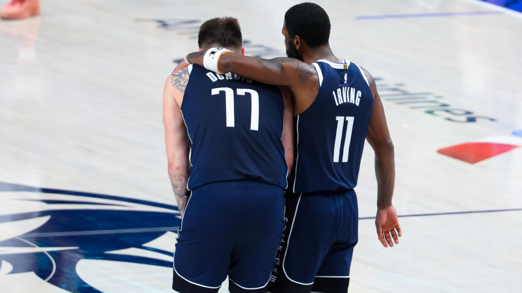 Dallas Mavericks guards Kyrie Irving and Luka Doncic embrace on the court