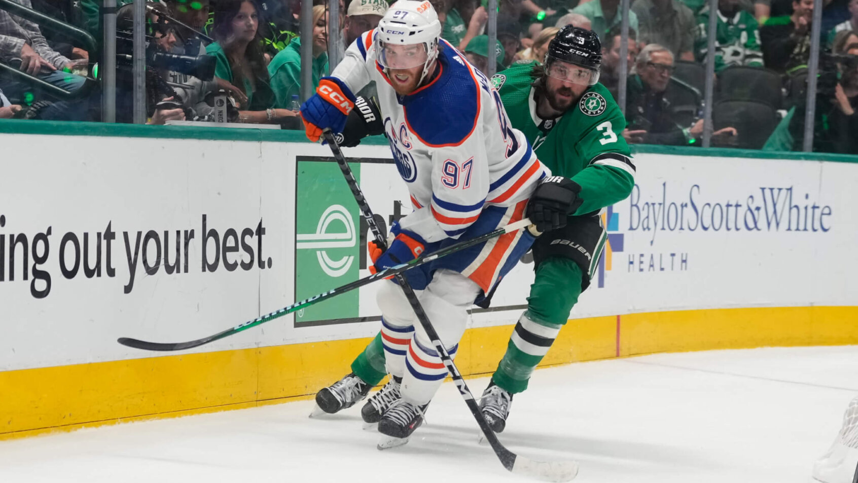 Edmonton Oilers center Connor McDavid and Dallas Stars defenseman Chris Tanev chase the puck