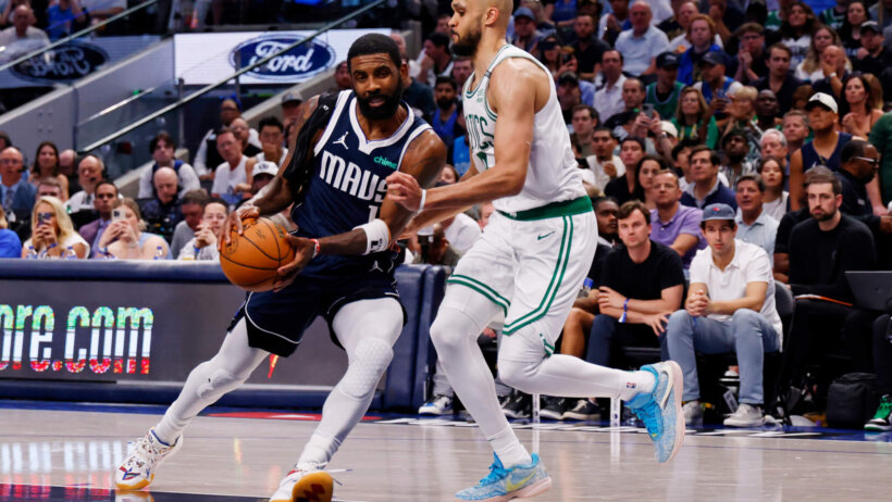 Dallas Mavericks guard Kyrie Irving drives the lane as Boston Celtics guard Derrick White defends