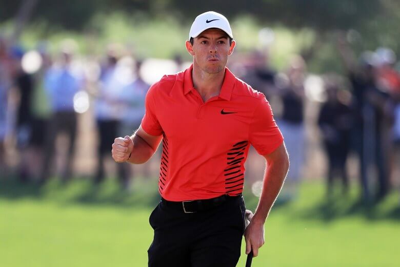 Rory McIlroy pumps his fist after making a putt.